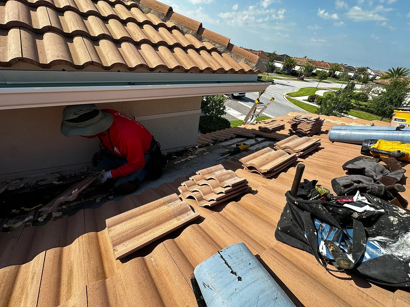 Remco crew in red shirts pulling up an old tile roof