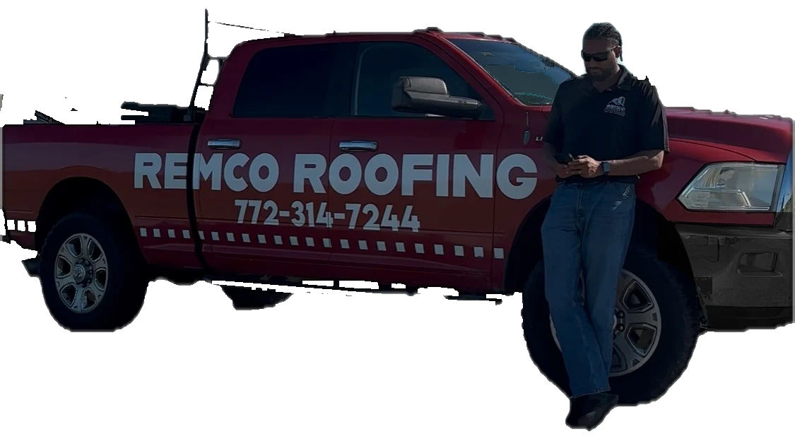 Devon Garcia, owner of Remco Roofing, leaning on his red Remco Roofing truck