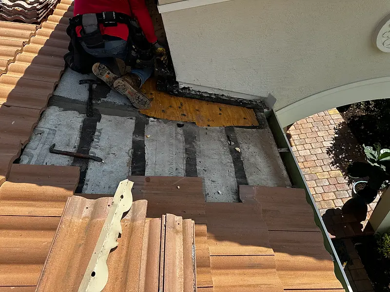Remco roofer repairing the deck under a tile roof