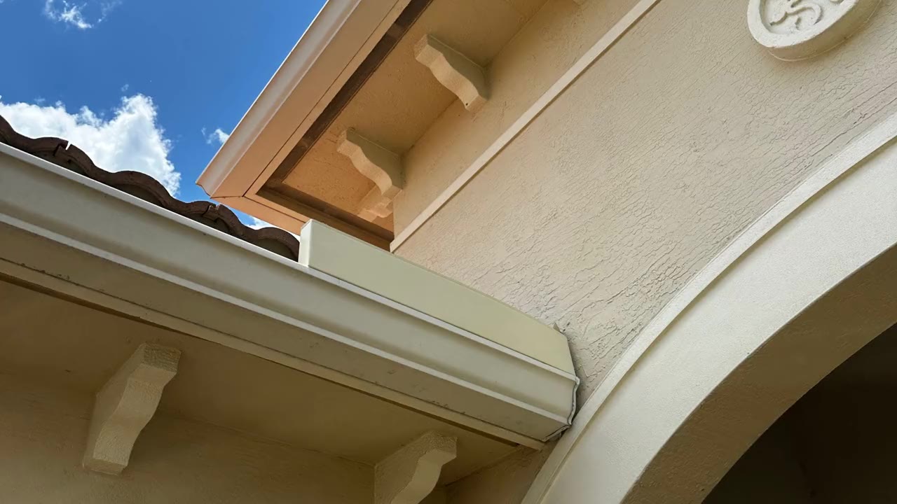 White seamless gutter along the eave of a stucco home