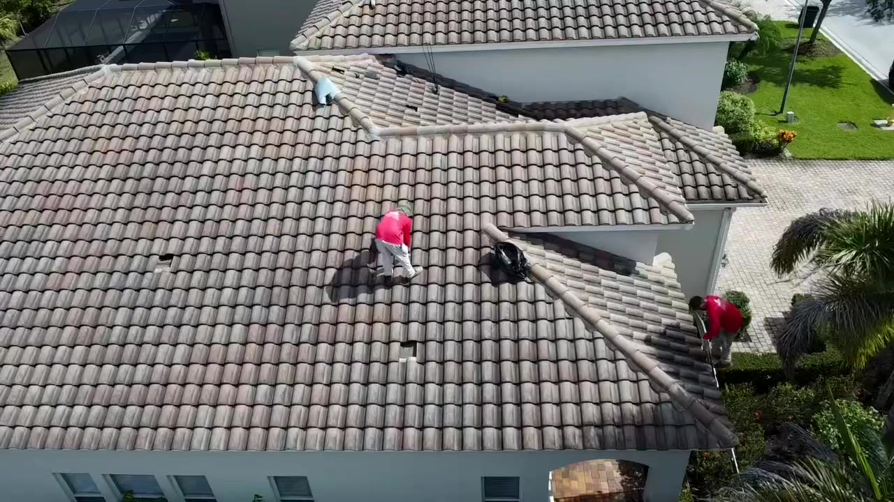 Remco roofer repairing a tile roof, seen from a drone
